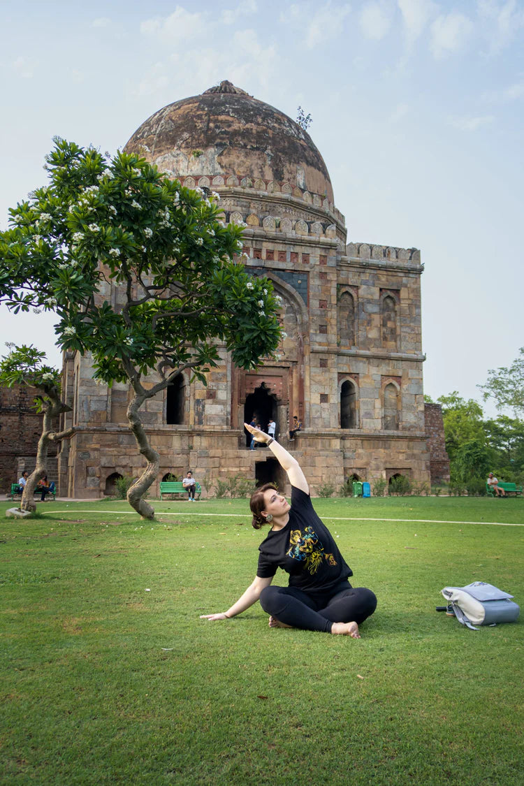 Fiatal nő jógázik a szabadban. A jóga segít a gerincproblémák megelőzésében és kezelésében.