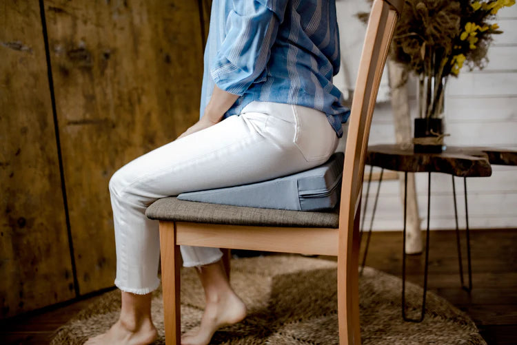Nő ül faszéken közeli kép-Benergo ergonomikus tartásjavító ékpárnán-amelyik segít az egészséges ülés kialakításában 