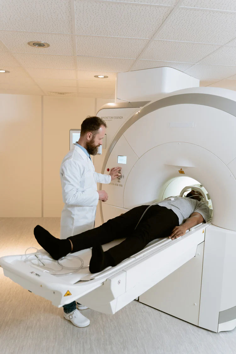 Fiatal szakember beteget vizsgál a CT készülékkel. Diagnosztikai technikák a gerincsérv esetén